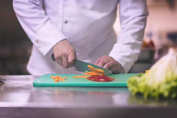 Image showing Chef hands cutting fresh and delicious vegetables