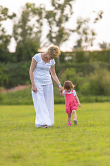 Image showing mother and little daughter playing at backyard