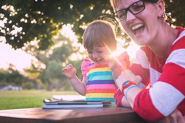 Image showing mom and her little daughter using tablet computer