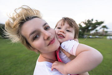 Image showing mother and little daughter playing at backyard