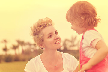 Image showing mother and little daughter playing at backyard