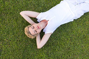 Image showing top view of young woman relaxing on the grass