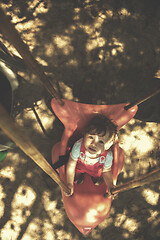 Image showing little girl swinging  on a playground