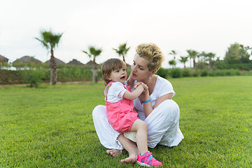 Image showing mother and little daughter playing at backyard