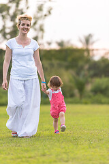 Image showing mother and little daughter playing at backyard