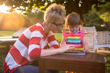 Image showing mom and her little daughter using tablet computer