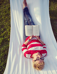 Image showing woman reading a book while relaxing on hammock