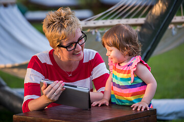 Image showing mom and her little daughter using tablet computer