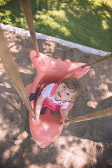 Image showing little girl swinging  on a playground