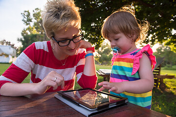 Image showing mom and her little daughter using tablet computer