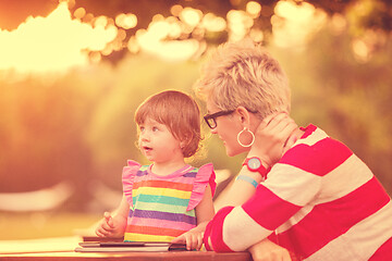 Image showing mom and her little daughter using tablet computer