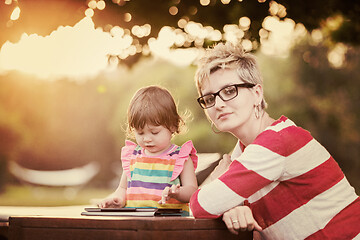 Image showing mom and her little daughter using tablet computer