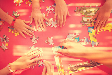 Image showing top view of kids hands playing with puzzles