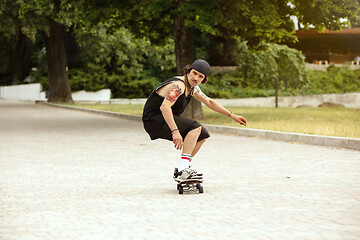 Image showing Skateboarder doing a trick at the city\'s street in cloudly day