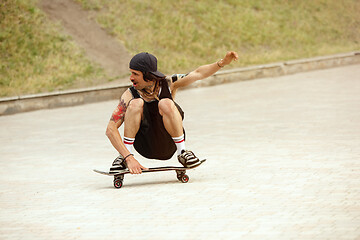 Image showing Skateboarder doing a trick at the city\'s street in cloudly day