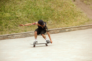 Image showing Skateboarder doing a trick at the city\'s street in cloudly day