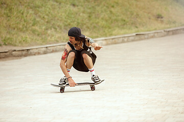 Image showing Skateboarder doing a trick at the city\'s street in cloudly day