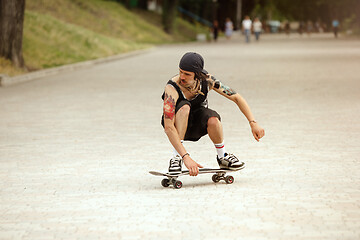 Image showing Skateboarder doing a trick at the city\'s street in cloudly day