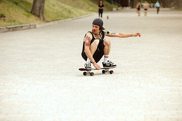 Image showing Skateboarder doing a trick at the city\'s street in cloudly day