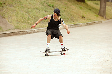 Image showing Skateboarder doing a trick at the city\'s street in cloudly day