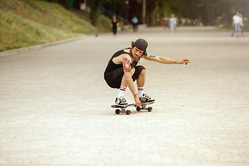 Image showing Skateboarder doing a trick at the city\'s street in cloudly day