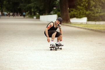 Image showing Skateboarder doing a trick at the city\'s street in cloudly day