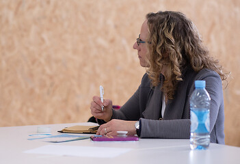 Image showing Business woman writing notes while working