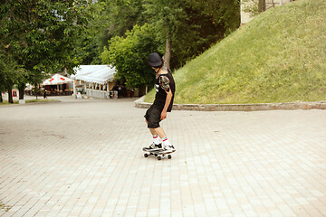 Image showing Skateboarder doing a trick at the city\'s street in cloudly day