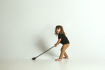 Image showing Little child sitting and playing in armchair on white studio background