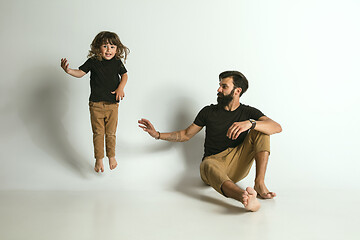 Image showing Father playing with young son against white studio background