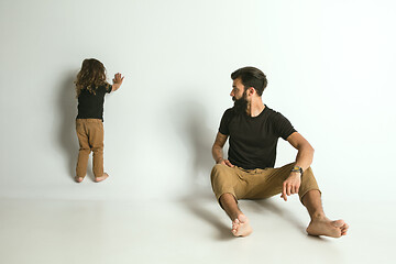 Image showing Father playing with young son against white studio background