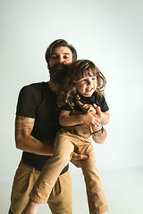 Image showing Father playing with young son against white studio background