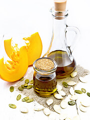 Image showing Oil pumpkin in jar and carafe on light board