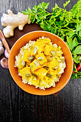 Image showing Porridge millet with spicy pumpkin in clay bowl on dark board to