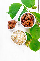 Image showing Flour and hazelnuts in bowls on light board top