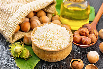 Image showing Flour in bowl with nuts on black wooden board