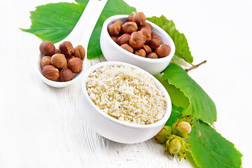 Image showing Flour and hazelnuts in bowls on board