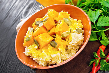 Image showing Porridge millet with spicy pumpkin in clay bowl on board