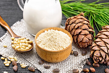 Image showing Flour cedar in bowl with nuts on dark board