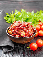 Image showing Tomatoes sun-dried in bowl with napkin on dark board