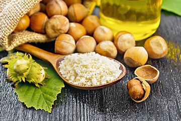 Image showing Flour in spoon with nuts on board