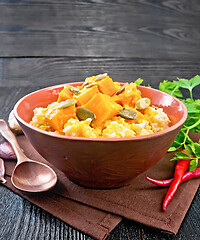 Image showing Porridge millet with spicy pumpkin in clay bowl on towel