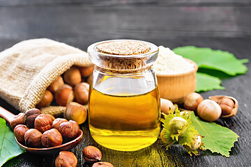 Image showing Oil hazelnut in jar on wooden board