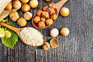 Image showing Flour and hazelnuts in two spoons on board top