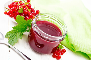 Image showing Jam of red currant in jar on white wooden board