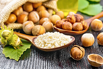 Image showing Flour and hazelnuts in two spoons on board