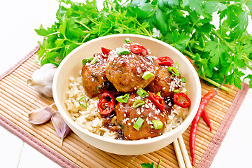 Image showing Meatballs in sweet and sour sauce with rice on bamboo napkin