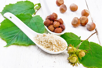 Image showing Flour and hazelnuts in spoons on board