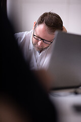 Image showing Business man writing notes while working on laptop