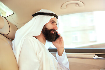 Image showing Arabian saudi businessman working in his car